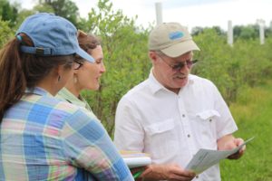 Dr. Kelly Garbach (center) speaks with Mark Longstroth (Michigan State University Extension) about results from the 2015 ICP survey of growers' pollination practices.
